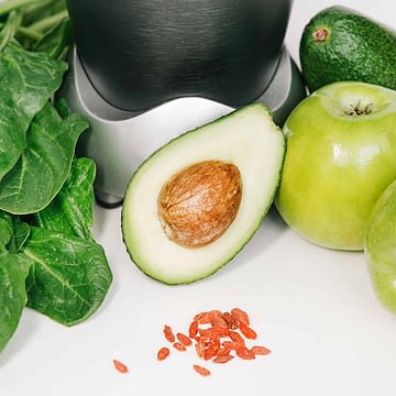 fitness blender with a set of healthy products, apple avocado spinach on a white background