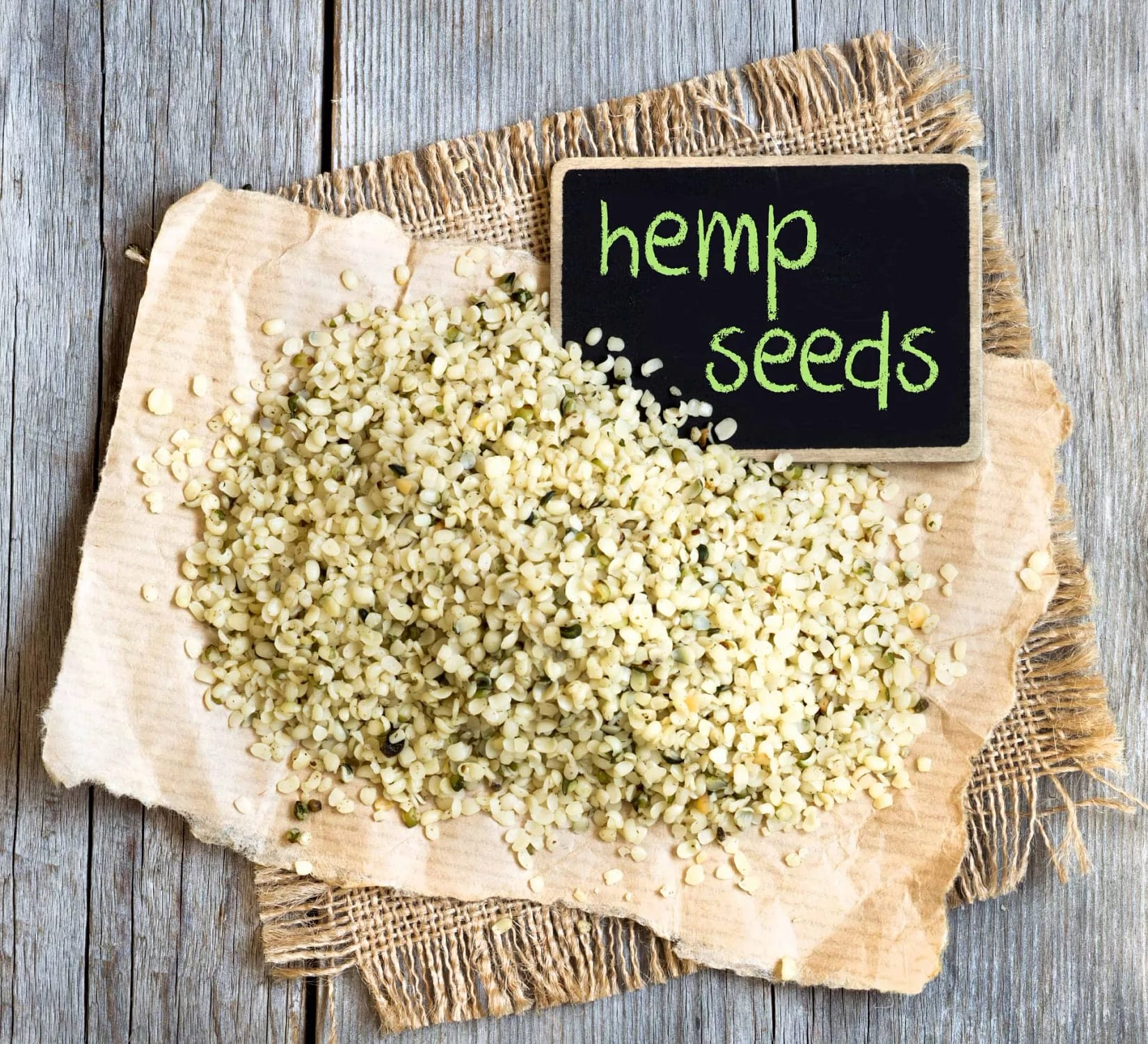 Hemp seeds on wooden table with small chalkboard