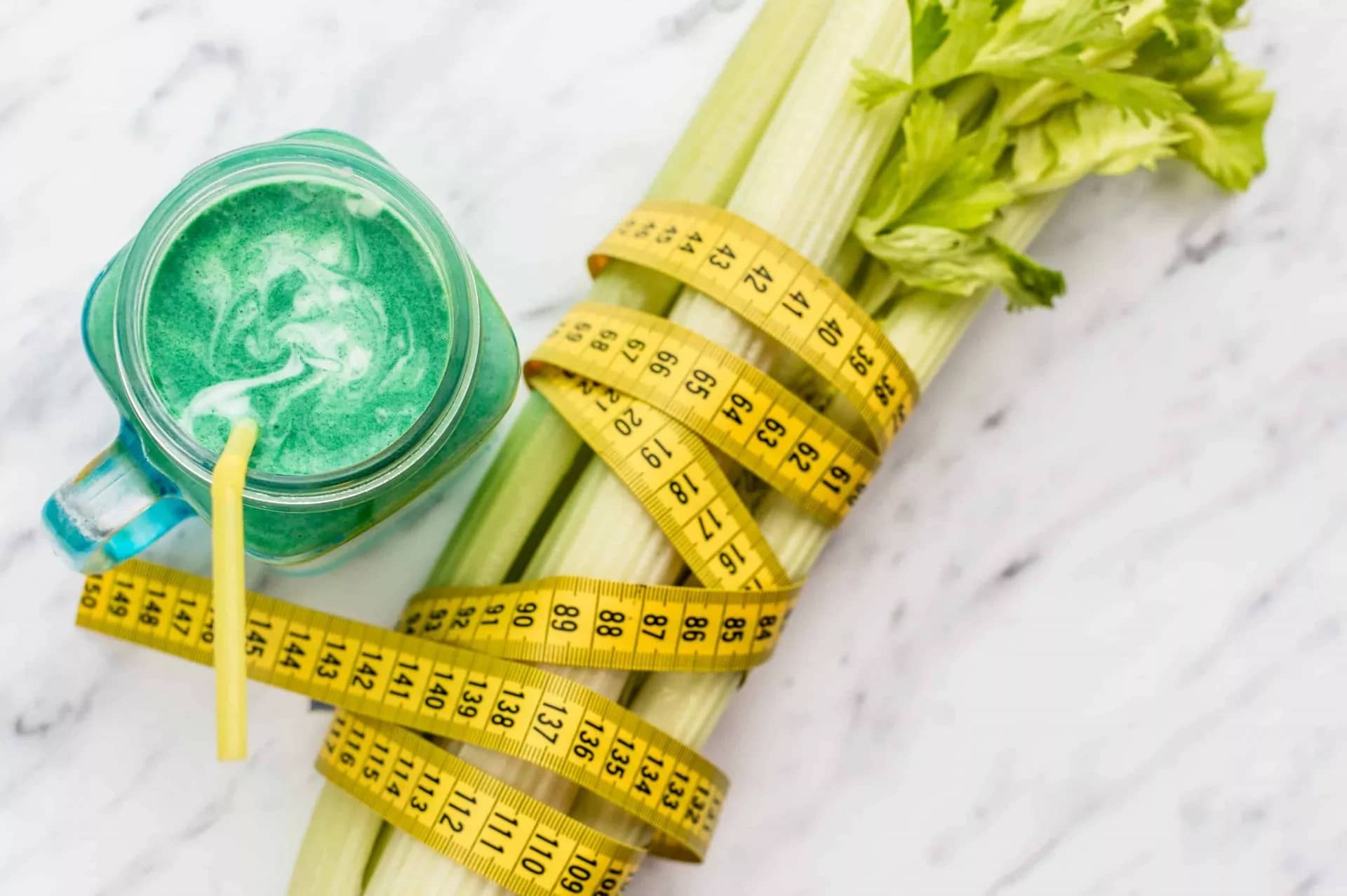 measuring tape wrapped around celery. concept weight loss