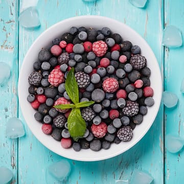 Frozen berries on a turquoise background, top view